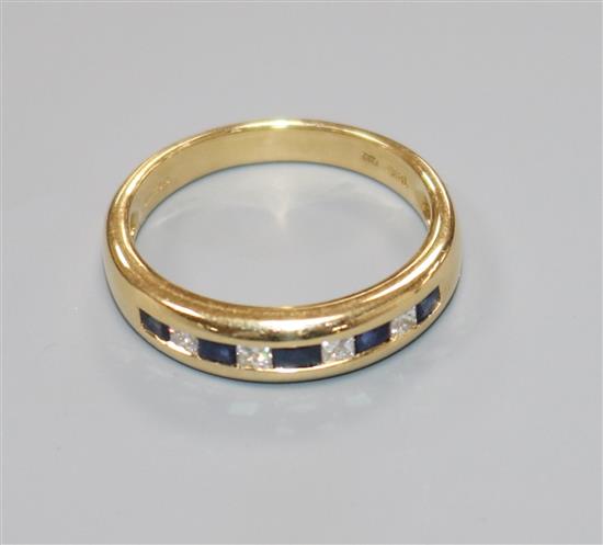 A modern 18ct gold and channel set sapphire and diamond nine stone half hoop ring, size N.